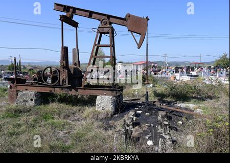 ALBANIEN, Kuçova, benannt Stalin Stadt von 1950 to1991, Rohölfeld und alte Bohrpumpe auf dem Friedhof, immer noch in Betrieb und umweltschädlich / ALBANIEN, Kucova, von 1950 bis 1991 Qyteti Stalin, Stalinstadt, Erdölförderung, alte Oelförderpumpe, die heute noch zur Ölförderung in Betrieb sind, an einem Friedhof Stockfoto