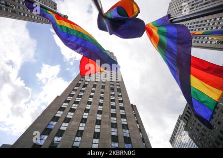 Regenbogenflaggen auf der Rockefeller Plaza zur Feier des Internationalen LGBT Pride Day, als Manhattan in die Phase 2 der Wiedereröffnung geht, nachdem am 26. Juni 2020 in New York City Beschränkungen zur Eindämmung der Coronavirus-Pandemie auferlegt wurden. Phase 2 ermöglicht die Wiedereröffnung von Büros, Ladengeschäften, Restaurants im Freien, Friseuren und Schönheitssalons sowie zahlreichen anderen Unternehmen. Phase 2 ist die zweite der vom Staat festgelegten vier Phasen. (Foto von John Nacion/NurPhoto) Stockfoto