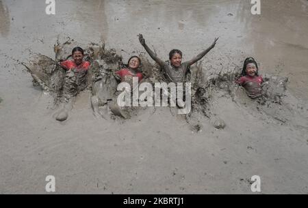 Kinder spielen im Schlamm auf dem Reisfeld während des National Paddy Day, der auch Asar Pandra am Stadtrand von Kathmandu, Nepal, genannt wird, am 29. Juni 2020. Nepalesen feiern den National Paddy Day mit Plantinf-Reiskulturen, Palyinf im Schlammwasser, Singen beim Essen von Joghurt und geschlagenem Reis zu Beginn der Monsunsaison. (Foto von Sunil Pradhan/NurPhoto) Stockfoto