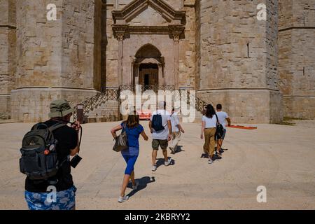 Touristen, gefolgt von einem Reiseleiter vor dem Castel del Monte in der Nähe von Andria, Italien, am 1.. Juli 2020. Das Castel del Monte wurde am 1. Juli mit gestaffelten Schichten und einer begrenzten Anzahl von Personen in Gruppen wiedereröffnet. Es wurden Sicherheitsmaßnahmen, physische Distanzierung und die obligatorische Verwendung der Maske eingeführt. Die Fremdenführer werden ihre Arbeit im Inneren des Schlosses nicht ausführen können, da es keine Lüftung hat und Versammlungen, sondern nur draußen vermieden werden. (Foto von Davide Pischettola/NurPhoto) Stockfoto