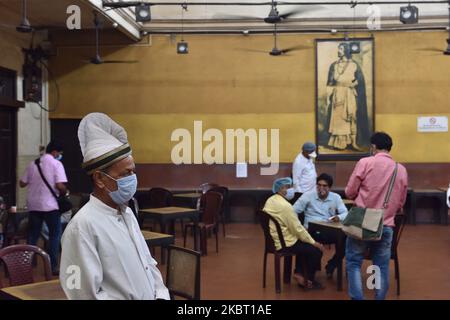 Ein Kellner mit einer schützenden Gesichtsmaske und einem Bildschirm bedient am 2. Juli 2020 Menschen in einem Kaffeehaus in Kalkutta, Indien. Das Indian Coffee House oder das College Street Coffee House ist eines der ältesten und renommiertesten Restaurants in Kalkutta. Aufgrund der COVID-19-Pandemie wurde sie für die langen drei Monate wegen Sperrung geschlossen. Heute wird sie nach vollständiger Säuberung durch die Stadtgesellschaft Kalkutta wieder eröffnet. Die Verwaltung hat umfassende Sicherheitsvorkehrungen getroffen, damit alle Kunden und auch die Mitarbeiter vor der thermischen Untersuchung und der Desinfektion schützen können (Foto: Sukhom Stockfoto