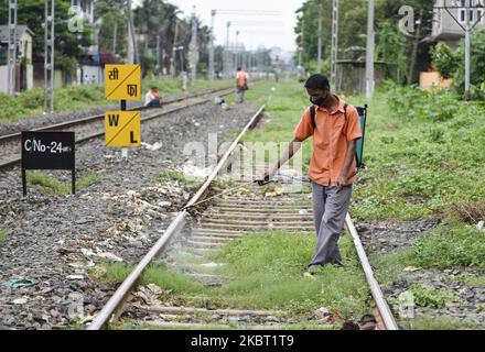 Ein Eisenbahner sprüht Desinfektionsmittel während der totalen Sperrung, die die Regierung Assam am am 02. Juli 2020 in Guwahati, Assam, Indien, zur Eindämmung der Ausbreitung des neuartigen Coronavirus verhängt hatte, auf eine Eisenbahnstrecke. (Foto von David Talukdar/NurPhoto) Stockfoto