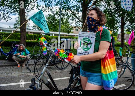 Ein Klimaaktivist hält während der Fahrradkampagne „Extinction Rebellion“ gegen das KLM-Unterstützungspaket am 3. Juli 2020 in Amsterdam, Niederlande, ein Plakat gegen Flugzeuge. (Foto von Romy Arroyo Fernandez/NurPhoto) Stockfoto