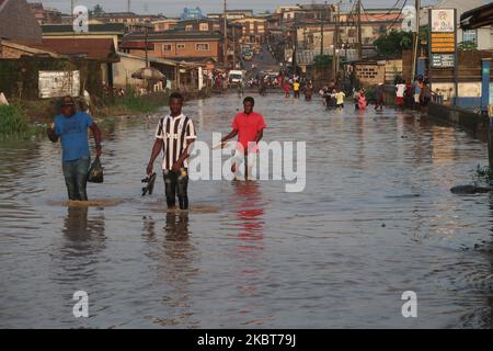 Die Bewohner waten durch die überflutete IgE Road, Aboru, Lagos. Die Überschwemmung störte die Bewegung und die sozioökonomischen Aktivitäten im Alabede-Gebiet der IgE Road, Aboru, Lagos, Nigeria, nach einem heftigen Regenguss am 6. Juli 2020. (Foto von Adekunle Ajayi/NurPhoto) Stockfoto