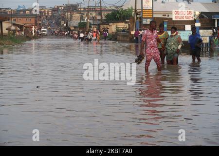 Die Bewohner waten durch die überflutete IgE Road, Aboru, Lagos. Die Überschwemmung störte die Bewegung und die sozioökonomischen Aktivitäten im Alabede-Gebiet der IgE Road, Aboru, Lagos, Nigeria, nach einem heftigen Regenguss am 6. Juli 2020. (Foto von Adekunle Ajayi/NurPhoto) Stockfoto