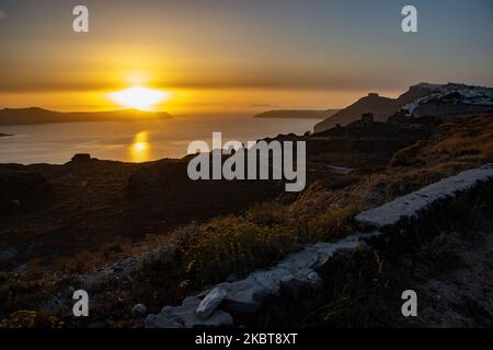 Blick auf den Sonnenuntergang von Thera auf Santorini, Kykladen in der Ägäis in Griechenland. Einige Touristen und Einheimische genießen den magischen Sonnenuntergang über dem Vulkan in Fira, als das Land die Flughäfen öffnete und Touristen nach dem 1. Juli aufgrund der allgemeinen Sperrmaßnahmen des Coronavirus Covid-19, die seit Juni 15 gelockert wurden, die Möglichkeit gab, nach dem Coronavirus zu kommen. Griechenland hat vor kurzem die touristische Sommersaison wieder eröffnet, und Premierminister Kyriakos Mitsotakis hielt während des Sonnenuntergangs eine Rede von Santorin, um die touristische Saison wieder in Gang zu bringen, da die griechische Wirtschaft stark darauf basiert. Juli 2020 (Foto von Nicolas Economou/ Stockfoto