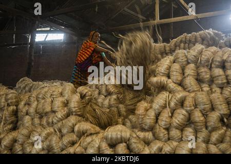 Eine Frau arbeitet am 11. Juli 2020 in einer Jute-Verarbeitungsfabrik in Narayanganj in der Nähe von Dhaka, Bangladesch. Jute, auch bekannt als die goldene Faser von Bangladesch, spielt eine wichtige Rolle in der nationalen Wirtschaft. Achtzig Prozent der weltweit hochwertigen Jute wächst in Bangladesch. Jute wird bei der Herstellung von Tuch, Tuch, Seilen, Teppich-Trägertuch, Büchsenbeuteln und vielen anderen nützlichen Dingen verwendet. Jutebeutel eignen sich sehr gut zum Verpacken von Lebensmittelkörnern. (Foto von Ahmed Salahuddin/NurPhoto) Stockfoto