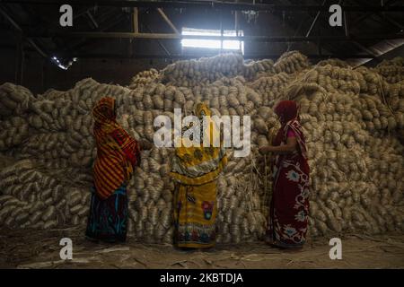 Am 11. Juli 2020 arbeiten Frauen in einer Jute-Verarbeitungsfabrik in Narayanganj in der Nähe von Dhaka, Bangladesch. Jute, auch bekannt als die goldene Faser von Bangladesch, spielt eine wichtige Rolle in der nationalen Wirtschaft. Achtzig Prozent der weltweit hochwertigen Jute wächst in Bangladesch. Jute wird bei der Herstellung von Tuch, Tuch, Seilen, Teppich-Trägertuch, Büchsenbeuteln und vielen anderen nützlichen Dingen verwendet. Jutebeutel eignen sich sehr gut zum Verpacken von Lebensmittelkörnern. (Foto von Ahmed Salahuddin/NurPhoto) Stockfoto