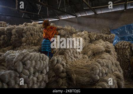 Eine Frau arbeitet am 11. Juli 2020 in einer Jute-Verarbeitungsfabrik in Narayanganj in der Nähe von Dhaka, Bangladesch. Jute, auch bekannt als die goldene Faser von Bangladesch, spielt eine wichtige Rolle in der nationalen Wirtschaft. Achtzig Prozent der weltweit hochwertigen Jute wächst in Bangladesch. Jute wird bei der Herstellung von Tuch, Tuch, Seilen, Teppich-Trägertuch, Büchsenbeuteln und vielen anderen nützlichen Dingen verwendet. Jutebeutel eignen sich sehr gut zum Verpacken von Lebensmittelkörnern. (Foto von Ahmed Salahuddin/NurPhoto) Stockfoto