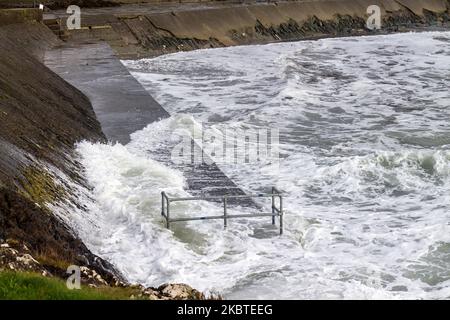 Sturmflutwellen brechen über die Verteidigung des Meeres. Tragumna, West Cork, Irland Stockfoto