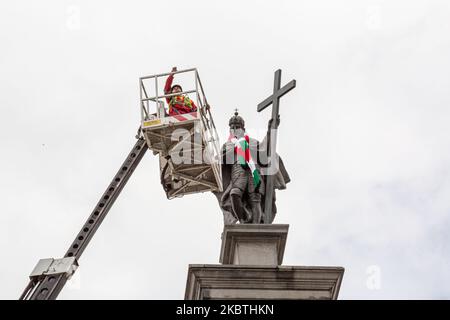 Cityhall-Arbeiter entfernen einen Schal des Fußballvereins Legia Warszawa, der illegal von Fußballfans auf einer markanten hohen Säulenstatue des polnischen Königs Zygmunt III Waza (Sigismund-Säule) aufgestellt wurde, da Legia Warszawa die Meisterschaften Polens am 11. Juli gewonnen hat - Warschau, Polen, 13. Juli 2020. Die Säule ist mehr als 10 Meter hoch und die Polizei kann nicht angeben, wie der Schal auf den Hals der Statue gelegt wurde. (Foto von Dominika Zarzycka/NurPhoto) Stockfoto