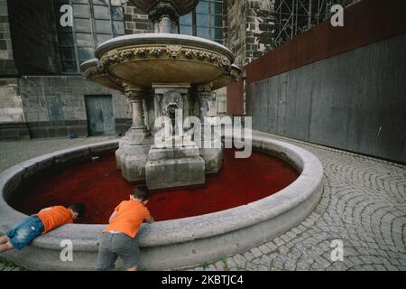 Zwei Kinder spielen am 13. Juli 2020 in Köln mit dem kontaminierten roten Petrus-Brunnen. (Foto von Ying Tang/NurPhoto) Stockfoto