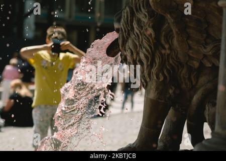 Ein Kind fotografiert am 13. Juli 2020 den roten petrus-Brunnen in Köln. (Foto von Ying Tang/NurPhoto) Stockfoto