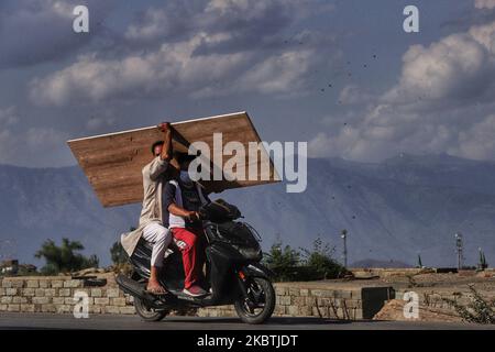 Kashmiri-Männer tragen Sperrholz auf einem Fahrrad in der zweiten Stadt des Distrikts Baramulla, Jammu und Kaschmir indien 13. Juli 2020 (Foto von Nasir Kachroo/NurPhoto) Stockfoto