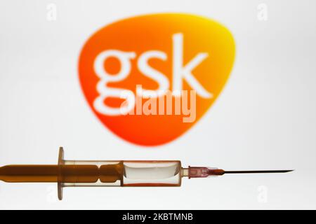 Die medizinische Spritze ist mit dem Firmenlogo von GlaxoSmithKline auf einem Bildschirm im Hintergrund auf diesem Illustrationsfoto zu sehen, das am 16. Juni 2020 in Polen aufgenommen wurde. (Fotoillustration von Jakub Porzycki/NurPhoto) Stockfoto