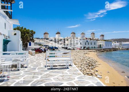 Die berühmten Windmühlen von Mykonos von Little Venice über dem Strand und das kristallklare Wasser. Die fast immer überfüllte Gegend Little Venice ist aufgrund der Coronavirus-Verkehrsbeschränkungen ohne viele Besucher. Die berühmten Windmühlen auf der Insel Mykonos, Kykladen-Inseln, Ägäis, Griechenland am 14. Juli 2020. Es gibt 16 Windmühlen auf der Insel, 5 davon oberhalb von Chora oder Mykonos Town, der Hauptstadt der Insel. Die Windmühlen wurden im 16.. Jahrhundert von den Venezianern gebaut, aber ihre Bauten dauerten bis zum 20.. Jahrhundert an. Die berühmte griechische Mittelmeerinsel wird als Spitzname bezeichnet Stockfoto