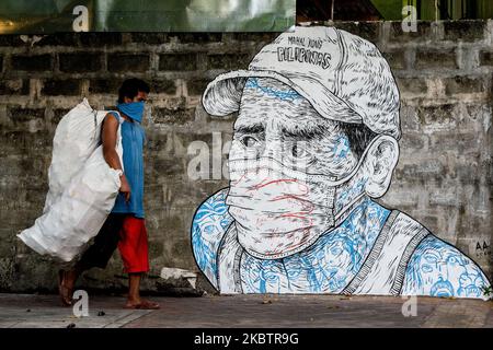 Ein Mann kommt am 17. Juli 2020 in Quezon City, Philippinen, an einem Wandgemälde vorbei, auf dem ein Mann abgebildet ist, dessen Mund und Nase mit einer Maske und einer Hand bedeckt sind. Die Gesamtzahl der bestätigten Fälle auf den Philippinen stieg auf 63, 001, nachdem heute 1.841 neue Fälle verzeichnet wurden.(Foto: Lisa Marie David/NurPhoto) Stockfoto