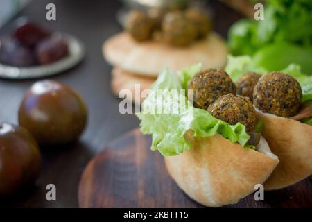 Falafel-Kugeln in einem Pita-Brot auf einer hölzernen Oberfläche Stockfoto