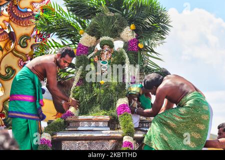 Tamilische Hindu-Anhänger bereiten sich vor, das Idol von Herrn Vinayagar (Herrn Ganesh) vom Wagen in Richtung zum Tempel während des Vinayagar Ther Thiruvizha Festivals an einem tamilischen Hindu-Tempel in Ontario, Kanada am 23. Juli 2016 zu tragen. Das Idol ist grün geschmückt und mit kaltem Wasser besprüht, was die Gottheit vor all der Aufregung, die während der Führung durch den Tempel von außen erlebt wird, beruhigen soll. Dieses Festival ist Teil des 15 Tage langen Festivals, das Lord Murugan ehrt, das mit einer extravaganten Wagenprozession gipfelt. (Foto von Creative Touch Imaging Ltd./NurPhoto) Stockfoto