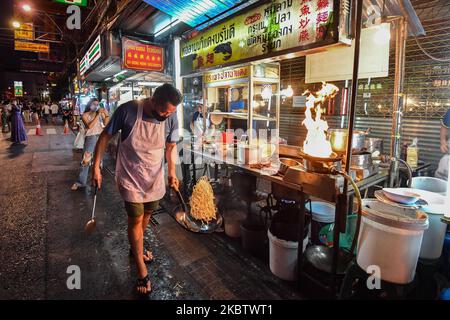 Am 19. Juli 2020 in Bangkok, Thailand, wird ein Mann mit Gesichtsmaske beim Kochen einer frittierten Nudel an seinem Street Food-Stand in Yaowarat (Chinatown) gesehen. (Foto von Vachira Vachira/NurPhoto) Stockfoto