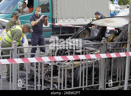 Ukrainische Polizisten arbeiten am 22. Juli 2020 am Tatort in der Nähe eines verbrannten Autos im Zentrum von Kiew, Ukraine. Zwei Autos, die am Straßenrand in der Nähe einer U-Bahn-Station im Zentrum der ukrainischen Hauptstadt geparkt wurden, brandeten in Flammen, das Feuer breitete sich von einem Auto zum anderen aus, wie lokale Medien berichteten. Die Polizei führt primäre Ermittlungsmaßnahmen durch und legt die Umstände und Ursachen des Feuers fest. (Foto von STR/NurPhoto) Stockfoto