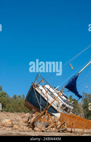 Segelboot gestrandet an Land wegen Dürre mit blauem Himmel Stockfoto