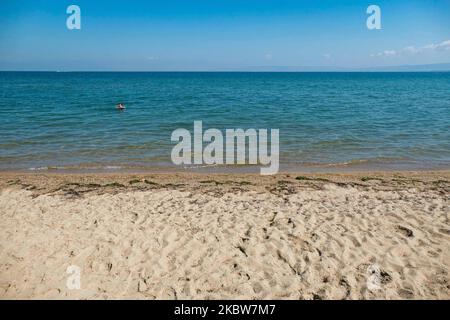 Alltag am Sandstrand von Agia Triada in der Nähe von Thessaloniki in Griechenland am 26. Juli 2020. Agia Triada ist ein Sommer-Touristenziel für Einheimische und ausländische Touristen für Ferien vor allem aus den Balkanländern. Der Strand ist mit der Blauen Flagge ausgezeichnet, hat typisch für griechische Strände und die Ägäis, kristallklares, transparentes Meerwasser, goldenen Sand und viele touristische Einrichtungen wie eine Fußgängerzone Uferstraße neben dem Ufer, kostenlose Duschen usw. Es gibt Hotels, Tavernen, Restaurants, Bars und Strandbars in der Gegend, die nur ein paar Minuten Fahrt vom internationalen Flughafen Thessaloniki entfernt ist Stockfoto