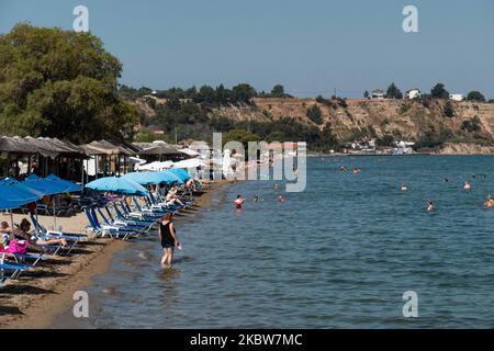 Alltag am Sandstrand von Agia Triada in der Nähe von Thessaloniki in Griechenland am 26. Juli 2020. Agia Triada ist ein Sommer-Touristenziel für Einheimische und ausländische Touristen für Ferien vor allem aus den Balkanländern. Der Strand ist mit der Blauen Flagge ausgezeichnet, hat typisch für griechische Strände und die Ägäis, kristallklares, transparentes Meerwasser, goldenen Sand und viele touristische Einrichtungen wie eine Fußgängerzone Uferstraße neben dem Ufer, kostenlose Duschen usw. Es gibt Hotels, Tavernen, Restaurants, Bars und Strandbars in der Gegend, die nur ein paar Minuten Fahrt vom internationalen Flughafen Thessaloniki entfernt ist Stockfoto