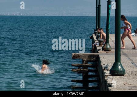 Alltag am Sandstrand von Agia Triada in der Nähe von Thessaloniki in Griechenland am 26. Juli 2020. Agia Triada ist ein Sommer-Touristenziel für Einheimische und ausländische Touristen für Ferien vor allem aus den Balkanländern. Der Strand ist mit der Blauen Flagge ausgezeichnet, hat typisch für griechische Strände und die Ägäis, kristallklares, transparentes Meerwasser, goldenen Sand und viele touristische Einrichtungen wie eine Fußgängerzone Uferstraße neben dem Ufer, kostenlose Duschen usw. Es gibt Hotels, Tavernen, Restaurants, Bars und Strandbars in der Gegend, die nur ein paar Minuten Fahrt vom internationalen Flughafen Thessaloniki entfernt ist Stockfoto