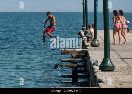 Alltag am Sandstrand von Agia Triada in der Nähe von Thessaloniki in Griechenland am 26. Juli 2020. Agia Triada ist ein Sommer-Touristenziel für Einheimische und ausländische Touristen für Ferien vor allem aus den Balkanländern. Der Strand ist mit der Blauen Flagge ausgezeichnet, hat typisch für griechische Strände und die Ägäis, kristallklares, transparentes Meerwasser, goldenen Sand und viele touristische Einrichtungen wie eine Fußgängerzone Uferstraße neben dem Ufer, kostenlose Duschen usw. Es gibt Hotels, Tavernen, Restaurants, Bars und Strandbars in der Gegend, die nur ein paar Minuten Fahrt vom internationalen Flughafen Thessaloniki entfernt ist Stockfoto