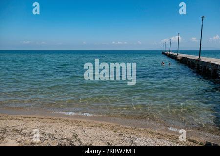 Alltag am Sandstrand von Agia Triada in der Nähe von Thessaloniki in Griechenland am 26. Juli 2020. Agia Triada ist ein Sommer-Touristenziel für Einheimische und ausländische Touristen für Ferien vor allem aus den Balkanländern. Der Strand ist mit der Blauen Flagge ausgezeichnet, hat typisch für griechische Strände und die Ägäis, kristallklares, transparentes Meerwasser, goldenen Sand und viele touristische Einrichtungen wie eine Fußgängerzone Uferstraße neben dem Ufer, kostenlose Duschen usw. Es gibt Hotels, Tavernen, Restaurants, Bars und Strandbars in der Gegend, die nur ein paar Minuten Fahrt vom internationalen Flughafen Thessaloniki entfernt ist Stockfoto