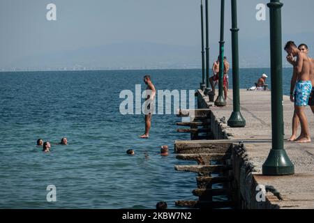 Alltag am Sandstrand von Agia Triada in der Nähe von Thessaloniki in Griechenland am 26. Juli 2020. Agia Triada ist ein Sommer-Touristenziel für Einheimische und ausländische Touristen für Ferien vor allem aus den Balkanländern. Der Strand ist mit der Blauen Flagge ausgezeichnet, hat typisch für griechische Strände und die Ägäis, kristallklares, transparentes Meerwasser, goldenen Sand und viele touristische Einrichtungen wie eine Fußgängerzone Uferstraße neben dem Ufer, kostenlose Duschen usw. Es gibt Hotels, Tavernen, Restaurants, Bars und Strandbars in der Gegend, die nur ein paar Minuten Fahrt vom internationalen Flughafen Thessaloniki entfernt ist Stockfoto