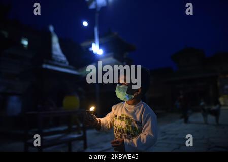 Der 20 Monate alte Nayan Maharjan, der am Mittwoch, den 29. Juli, im Bagh Bhairab Temple-Gebäude in Kirtipur, Kathmandu, Nepal, Butterlampen anbot, 2020. Die meisten religiösen Tempel öffnen nach 4 Monaten Lockdown in Nepal. (Foto von Narayan Maharjan/NurPhoto) Stockfoto