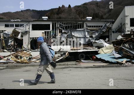 25. März 2011-Kamaishi, ein Überlebender der der japanischen Ureinwohner, übergeht am 25. März 2011 in Japan Trümmer und Schlamm, der bei einem Tsunami-Schlag bedeckt wurde, die zerstörte Minenstadt in Kamaishi. Am 11. März 2011 ereignete sich in Japan ein Erdbeben mit einer Magnitude von 9,0, dem größten in der Geschichte des Landes und einem der fünf mächtigsten, die jemals auf der ganzen Welt verzeichnet wurden. Innerhalb einer Stunde nach dem Erdbeben wurden die Städte, die das Ufer säumten, durch einen massiven Tsunami abgeflacht, der durch die Energie verursacht wurde, die durch das Erdbeben freigesetzt wurde. Mit Wellen von bis zu vier oder fünf Metern Höhe stürzten sie durch Häuser, Städte und Felder der Zivilbevölkerung. (Foto von Seung-il Ry Stockfoto