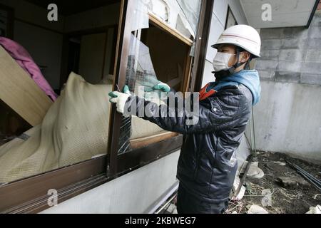 25. März 2011-Kamaishi, Japan-Überlebende der Ureinwohner reparieren mit Säuberung ihres Hauses auf Schutt und Schlamm, der bei dem Tsunami-Schlag bedeckt war zerstörte Minenstadt in Kamaishi am 25. März 2011, Japan. Am 11. März 2011 ereignete sich in Japan ein Erdbeben mit einer Magnitude von 9,0, dem größten in der Geschichte des Landes und einem der fünf mächtigsten, die jemals auf der ganzen Welt verzeichnet wurden. Innerhalb einer Stunde nach dem Erdbeben wurden die Städte, die das Ufer säumten, durch einen massiven Tsunami abgeflacht, der durch die Energie verursacht wurde, die durch das Erdbeben freigesetzt wurde. Mit Wellen von bis zu vier oder fünf Metern Höhe stürzten sie durch Häuser, Städte und Zivilpersonen Stockfoto