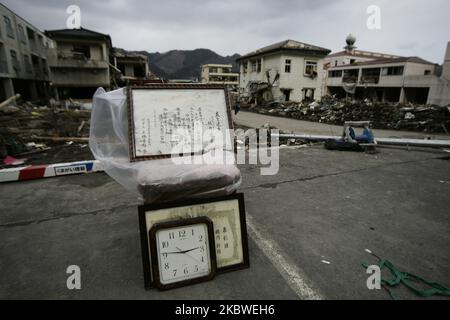 25. März 2011-Kamaishi, Japan-Bilderrahmen und beobachten auf der Straße zu Schutt und Schlamm bedeckt bei Tsunami getroffen zerstörte Minenstadt in Kamaishi am 25. März 2011, Japan. Am 11. März 2011 ereignete sich in Japan ein Erdbeben mit einer Magnitude von 9,0, dem größten in der Geschichte des Landes und einem der fünf mächtigsten, die jemals auf der ganzen Welt verzeichnet wurden. Innerhalb einer Stunde nach dem Erdbeben wurden die Städte, die das Ufer säumten, durch einen massiven Tsunami abgeflacht, der durch die Energie verursacht wurde, die durch das Erdbeben freigesetzt wurde. Mit Wellen von bis zu vier oder fünf Metern Höhe stürzten sie durch Häuser, Städte und Felder der Zivilbevölkerung Stockfoto