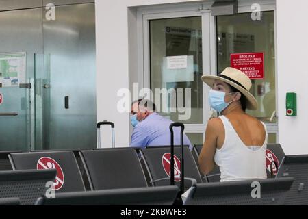 Passagiere, die mit Gesichtsmask warten, am Schalter zum Einsteigen einchecken und leere Sitzplätze mit Schildern blockieren, die sie im Bereich des Gates mit reduziertem Verkehr blockieren. Flug vom Athens International Airport ATH LGAV in Griechenland. Passagiere mit Gesichtsmasken und Schutzmaßnahmen wie Handschuhen, Händedesinfektionsmittel, Sitzblockierung, sozialer Distanzierung, Distanzschildern usw. aufgrund des Coronavirus Covid-19-Pandemieausbruchs, Sicherheitsmaßnahmen, wie sie an den Check-in-Schaltern, am Hauptabflugterminal und an den Gates zu sehen sind. Athen, Griechenland - Juli 2020 (Foto von Nicolas Economou/NurPhoto) Stockfoto