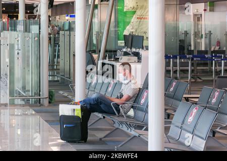 Passagiere, die mit Gesichtsmask warten, am Schalter zum Einsteigen einchecken und leere Sitzplätze mit Schildern blockieren, die sie im Bereich des Gates mit reduziertem Verkehr blockieren. Flug vom Athens International Airport ATH LGAV in Griechenland. Passagiere mit Gesichtsmasken und Schutzmaßnahmen wie Handschuhen, Händedesinfektionsmittel, Sitzblockierung, sozialer Distanzierung, Distanzschildern usw. aufgrund des Coronavirus Covid-19-Pandemieausbruchs, Sicherheitsmaßnahmen, wie sie an den Check-in-Schaltern, am Hauptabflugterminal und an den Gates zu sehen sind. Athen, Griechenland - Juli 2020 (Foto von Nicolas Economou/NurPhoto) Stockfoto