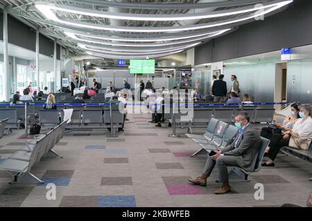 Passagiere, die mit Gesichtsmask warten, am Schalter zum Einsteigen einchecken und leere Sitzplätze mit Schildern blockieren, die sie im Bereich des Gates mit reduziertem Verkehr blockieren. Flug vom Athens International Airport ATH LGAV in Griechenland. Passagiere mit Gesichtsmasken und Schutzmaßnahmen wie Handschuhen, Händedesinfektionsmittel, Sitzblockierung, sozialer Distanzierung, Distanzschildern usw. aufgrund des Coronavirus Covid-19-Pandemieausbruchs, Sicherheitsmaßnahmen, wie sie an den Check-in-Schaltern, am Hauptabflugterminal und an den Gates zu sehen sind. Athen, Griechenland - Juli 2020 (Foto von Nicolas Economou/NurPhoto) Stockfoto