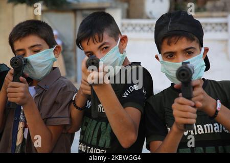 Syrische Kinder spielen am ersten Tag des gesegneten Eid al-Adha-Feiertages in Idlib, Nordwest-Syrien, am 31. Juli 2020 mit Plastikwaffen. (Foto von Muhammad al-Rifai/NurPhoto) Stockfoto