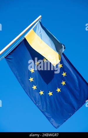 Die EU-Flagge zusammen mit einer ukrainischen Flagge vor einem blauen Himmel Stockfoto