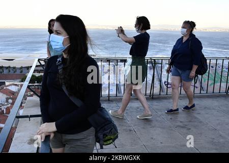 Touristen mit Schutzmasken beobachten die Stadt Lissabon vom Standpunkt Santa Luzia aus, 31. Juli 2020. Gesundheitsministerin Marta Temido berichtete, dass es in Portugal 12.864 aktive Fälle von COVID-19-Krankheit gibt, einschließlich ausbruchsbedingter Infektionen. Insgesamt gibt es 194 aktive Ausbrüche im Land: 47 in der Nordregion, 12 in der Mitte, 106 in Lissabon und im Tejo-Tal, 14 in der Alentejo und 15 in der Algarve. Die Ausbrüche gelten auch dann als aktiv, wenn seit dem letzten bestätigten Fall mehrere Tage vergangen sind. „Wir betrachten einen Ausbruch nur als ausgestorben, wenn 28 Tage (zwei inkubiert Stockfoto