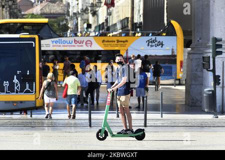 Ein Mann mit Schutzmasken fährt mit dem Roller in Praça de Comércio, Lissabon. 31.. Juli 2020. Gesundheitsministerin Marta Temido berichtete, dass es in Portugal 12.864 aktive Fälle von COVID-19-Krankheit gibt, einschließlich ausbruchsbedingter Infektionen. Insgesamt gibt es 194 aktive Ausbrüche im Land: 47 in der Nordregion, 12 in der Mitte, 106 in Lissabon und im Tejo-Tal, 14 in der Alentejo und 15 in der Algarve. Die Ausbrüche gelten auch dann als aktiv, wenn seit dem letzten bestätigten Fall mehrere Tage vergangen sind. „Wir betrachten einen Ausbruch nur als ausgestorben, wenn 28 Tage (zwei Inkubationszeiten) vergehen Stockfoto