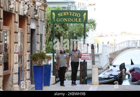 Am 17. Juni 2020 warten zwei Gondoliere auf eine Gondelfahrt auf dem Canale Grande in Venedig, Italien. Touristen kehren nach Venedig zurück, da das Land seine Sperre lockert, um die Ausbreitung der COVID-19-Infektion, die durch das neuartige Coronavirus verursacht wird, zu eindämmen. (Foto von Sabine Jacob/NurPhoto) Stockfoto