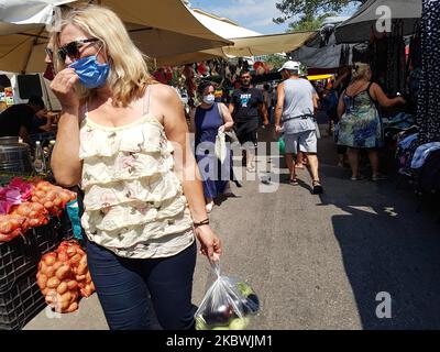 Eine Frau, die am 1. August 2020 auf dem Flohmarkt in Thessaloniki, Griechenland, einen Gesichtsmast trägt. Die Öffentlichkeit in Griechenland begann sich zu entspannen und die obligatorische soziale Distanzierung zu vermeiden und trug obligatorische Gesichtsmaskensicherheitsmaßnahmen wegen des Pandemieausbruchs des Coronavirus Covid-19 während eines der wärmsten Tage des Sommers, wobei die Temperatur lokal mehr als 40 Grad Celsius erreichte, Eine Hitzewelle, die vielleicht den heißesten Tag des Sommers geben wird. Menschen werden auf einem öffentlichen Straßenmarkt ohne Gesichtsmaske gesehen, ohne eine bestimmte Distanz zu haben und ohne dass jeder Verkäufer nur einen Kunden hat Stockfoto