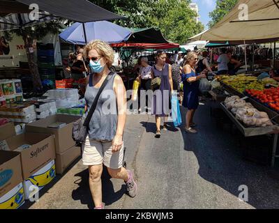 Eine Frau, die am 1. August 2020 auf dem Flohmarkt in Thessaloniki, Griechenland, einen Gesichtsmast trägt. Die Öffentlichkeit in Griechenland begann sich zu entspannen und die obligatorische soziale Distanzierung zu vermeiden und trug obligatorische Gesichtsmaskensicherheitsmaßnahmen wegen des Pandemieausbruchs des Coronavirus Covid-19 während eines der wärmsten Tage des Sommers, wobei die Temperatur lokal mehr als 40 Grad Celsius erreichte, Eine Hitzewelle, die vielleicht den heißesten Tag des Sommers geben wird. Menschen werden auf einem öffentlichen Straßenmarkt ohne Gesichtsmaske gesehen, ohne eine bestimmte Distanz zu haben und ohne dass jeder Verkäufer nur einen Kunden hat Stockfoto