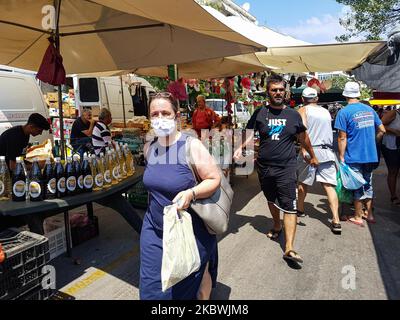 Eine Frau, die am 1. August 2020 auf dem Flohmarkt in Thessaloniki, Griechenland, einen Gesichtsmast trägt. Die Öffentlichkeit in Griechenland begann sich zu entspannen und die obligatorische soziale Distanzierung zu vermeiden und trug obligatorische Gesichtsmaskensicherheitsmaßnahmen wegen des Pandemieausbruchs des Coronavirus Covid-19 während eines der wärmsten Tage des Sommers, wobei die Temperatur lokal mehr als 40 Grad Celsius erreichte, Eine Hitzewelle, die vielleicht den heißesten Tag des Sommers geben wird. Menschen werden auf einem öffentlichen Straßenmarkt ohne Gesichtsmaske gesehen, ohne eine bestimmte Distanz zu haben und ohne dass jeder Verkäufer nur einen Kunden hat Stockfoto