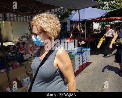 Eine Frau, die am 1. August 2020 auf dem Flohmarkt in Thessaloniki, Griechenland, einen Gesichtsmast trägt. Die Öffentlichkeit in Griechenland begann sich zu entspannen und die obligatorische soziale Distanzierung zu vermeiden und trug obligatorische Gesichtsmaskensicherheitsmaßnahmen wegen des Pandemieausbruchs des Coronavirus Covid-19 während eines der wärmsten Tage des Sommers, wobei die Temperatur lokal mehr als 40 Grad Celsius erreichte, Eine Hitzewelle, die vielleicht den heißesten Tag des Sommers geben wird. Menschen werden auf einem öffentlichen Straßenmarkt ohne Gesichtsmaske gesehen, ohne eine bestimmte Distanz zu haben und ohne dass jeder Verkäufer nur einen Kunden hat Stockfoto