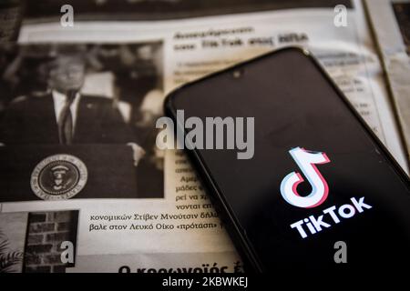 TikTok Nahaufhabzeichen auf einem Smartphone-Bildschirm und die lokale Zeitung von Chania, Kreta, Griechenland, am 3. August 2020. US-Präsident Donald Trump droht und plant, die beliebte Video-Sharing-App TikTok aus den USA wegen des Sicherheitsrisikos zu verbieten. (Fotoillustration von Nikolas Kokovlis/NurPhoto) Stockfoto