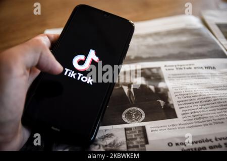 TikTok Nahaufhabzeichen auf einem Smartphone-Bildschirm und die lokale Zeitung von Chania, Kreta, Griechenland, am 3. August 2020. US-Präsident Donald Trump droht und plant, die beliebte Video-Sharing-App TikTok aus den USA wegen des Sicherheitsrisikos zu verbieten. (Fotoillustration von Nikolas Kokovlis/NurPhoto) Stockfoto